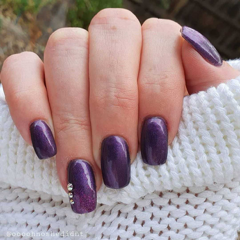 Nails showing deep rich classic purple shade with embellishments